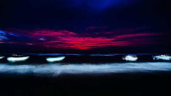 boats in ocean at night