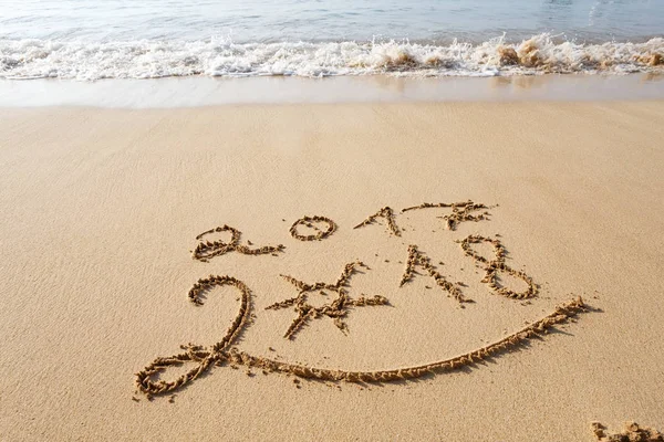 Happy New Year 2018 lettering on tropical beach sand