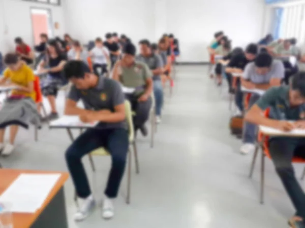 Flou étudiants écrivant réponse faire l'examen en classe — Photo