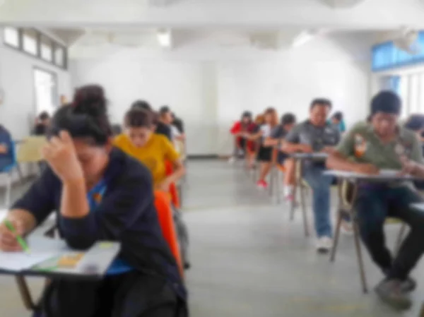 Flou étudiants écrivant réponse faire l'examen en classe — Photo