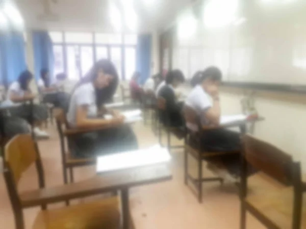 Vervagen de achtergrond universitaire studenten antwoord doet examen in te schrijven — Stockfoto
