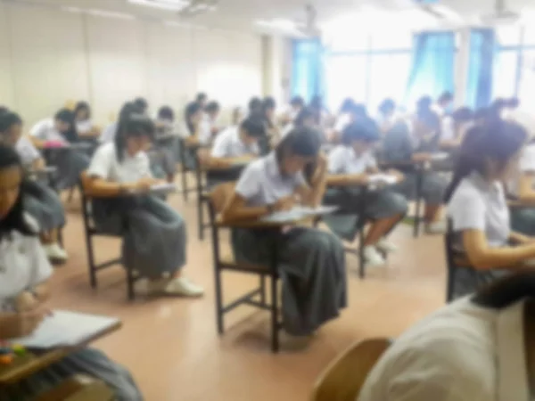 Vervagen de achtergrond universitaire studenten antwoord doet examen in te schrijven — Stockfoto