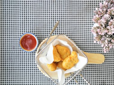 Masanın üzerinde bir tavada kızarmış nuggets içinde