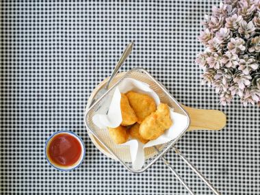 Masanın üzerinde bir tavada kızarmış nuggets içinde