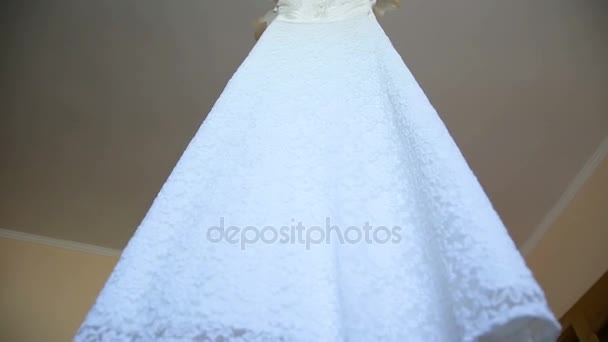 Den perfekta bröllopsklänningen med en hel kjol på en galge i brudens rum. — Stockvideo