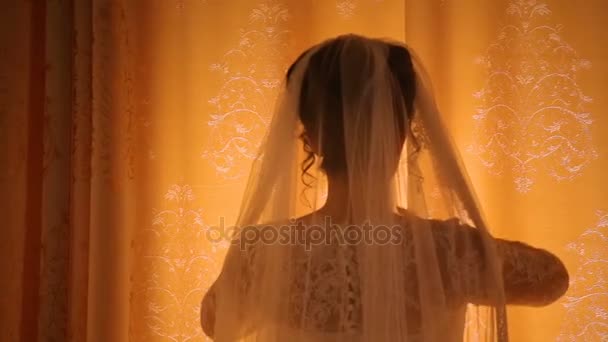 Νύφη ανοίγει μπεζ κουρτίνες που στέκεται πριν από φωτεινό παράθυρο — Αρχείο Βίντεο