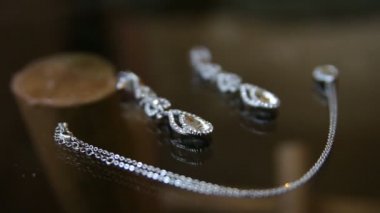 Küpe ve kolye ışıltı güneş ışığı altında olan bir zincir