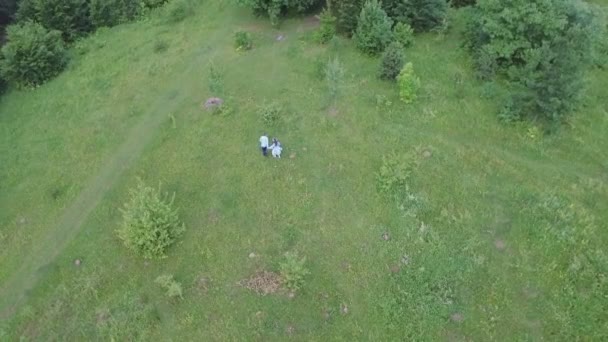 Fiatal pár birtoklás móka-on zöld mező a tavasszal vagy nyáron, általános terv — Stock videók