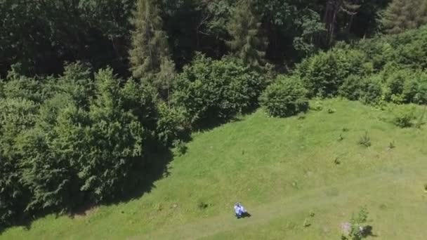 Pareja joven divirtiéndose en el campo verde en la primavera o el verano, plan general — Vídeos de Stock