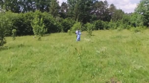 Giovane coppia divertirsi sul campo verde in primavera o in estate, piano generale — Video Stock