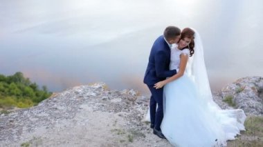 Evlilik çift şefkatle muhteşem manzaralı dağ tepe kenarındaki öpüşme