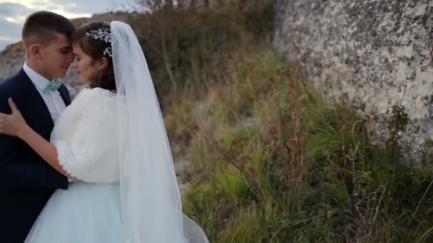 Matrimonio coppia teneramente baciare sul bordo vetta della montagna con vista incredibile — Video Stock