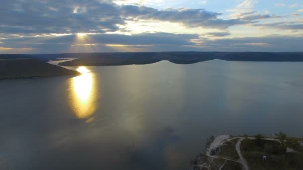大山之间的湖泊日落。一对情侣抱在悬崖边上。4k — 图库视频影像