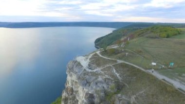 Harika gün batımı göl dağları arasında. Uçurumun kenarında sarılma bir çift. 4k