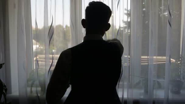 Silhouet van een man gekleed in de kamer — Stockvideo
