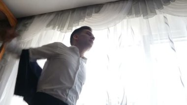 bir damat düğün için hazırlar ve onun yelek ve ceket siyah beyaz elbiseler. Düğün için onun ceket düğmesi gelecekteki kocası kapatır.