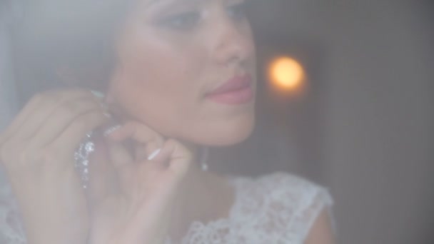 Sweet bride with a beautiful hair pulls on the earring. — Stock Video