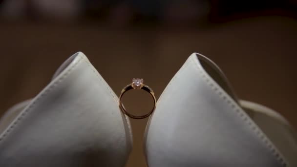 Обручальное кольцо между белыми туфлями . — стоковое видео