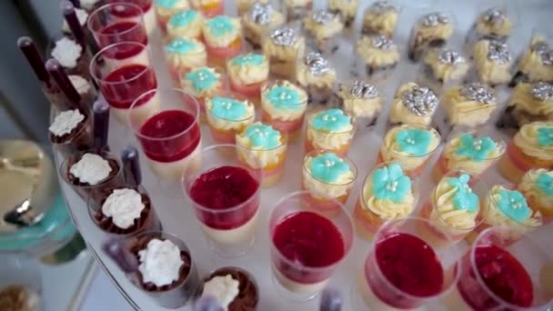 結婚式のレセプションでお客様に提供される果物、飲み物、甘いケーキやカップケーキの品揃え. — ストック動画