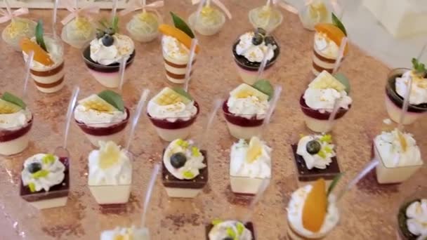 Uma variedade de frutas, bebidas, bolos doces e cupcakes oferecidos aos hóspedes na recepção do casamento . — Vídeo de Stock