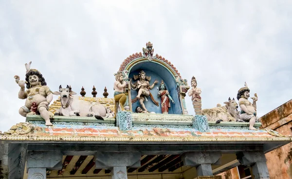 Статуи танцующего бога Шивы и богини Парвати, быка Нанди и других мифологических существ на крыше входа в древний храм Шивы XVIII века, Пондичерри, Южная Индия — стоковое фото