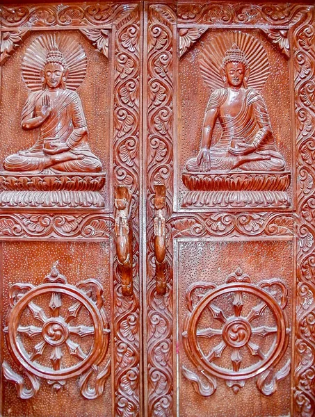 Porte in legno del vecchio monastero buddista del XVI secolo con immagini di Buddha e della ruota del dharma a Kathmandu, Nepal — Foto Stock