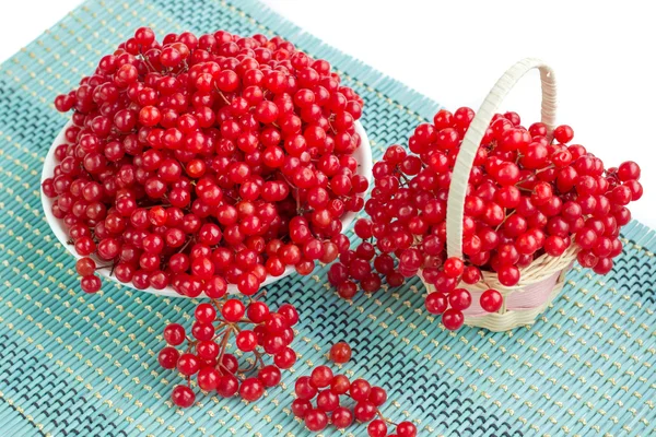 Красные ягоды в тарелке и корзина на голубой подкладке — стоковое фото