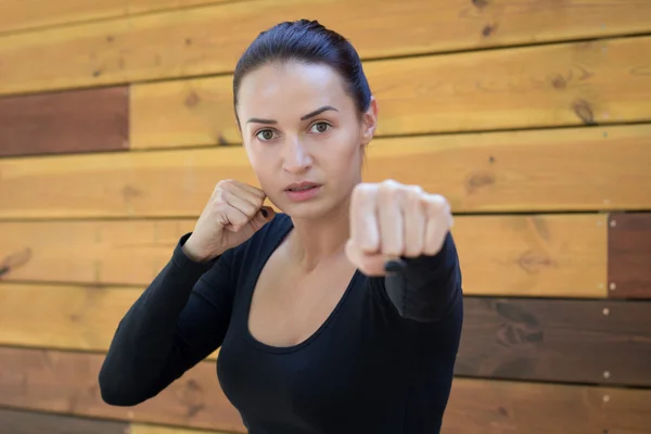 Young pretty fitness woman exercises during boxing workout