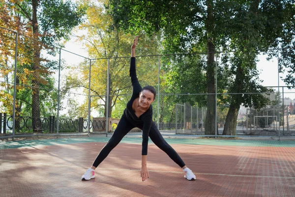 Молодая довольно фитнес женщина делает упражнения на растяжку во время трай — стоковое фото