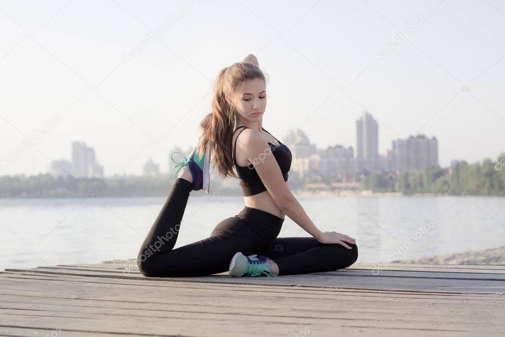 Sporty girl stretches at triangle pose during training workout o