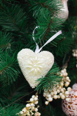 Beyaz kalp ve altın süs eşyaları ile Noel ağacı