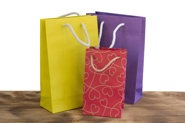 Paquetes de compras coloridos y brillantes para regalos en mesa de madera — Foto de Stock