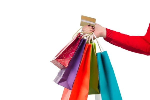 Pacchetti shopping colorati e carta bancaria nella mano destra femminile — Foto Stock