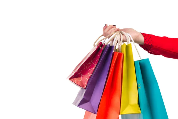 Versicolored och ljusa shopping paket hängande på kvinnliga röd ärm arm — Stockfoto