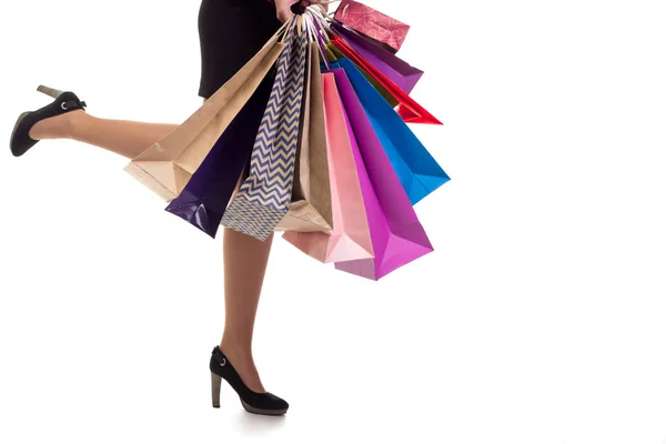 Нижний крупный план, женщина бежит держа пакеты с покупками и пака — стоковое фото