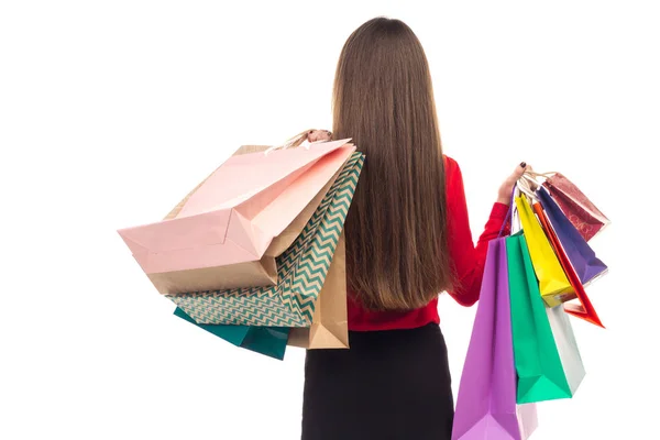 Long-haired girl from back holds multicolored shopping paper bag — Stock Photo, Image