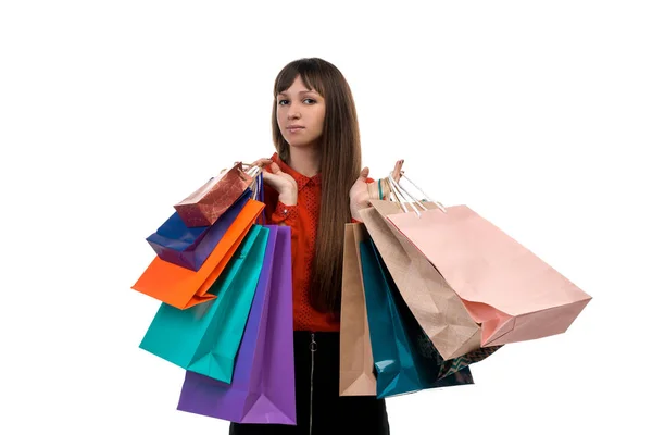 Young long-haired woman holds shopping purchases, many colorful — Stock Photo, Image