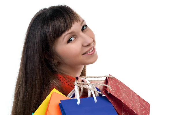 Giovane donna sorridente faccia con colorati sacchetti di carta shopping — Foto Stock