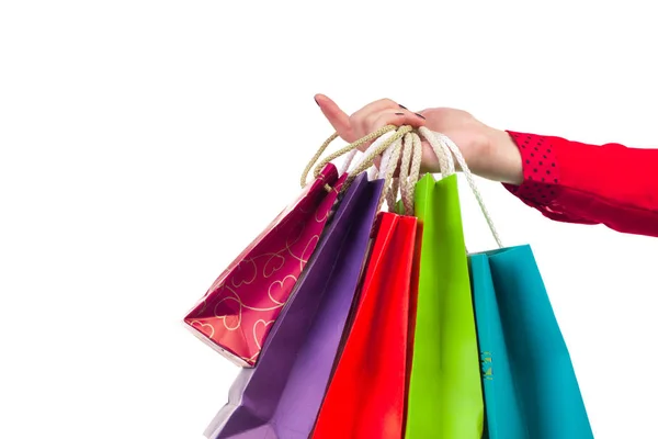 Embalagens de compras multicoloridas e brilhantes penduradas no vermelho fêmea — Fotografia de Stock