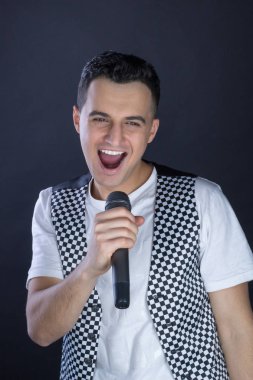 Genç erkek siyah saçlı rock şarkıcı şarkı microp gerçekleştirir