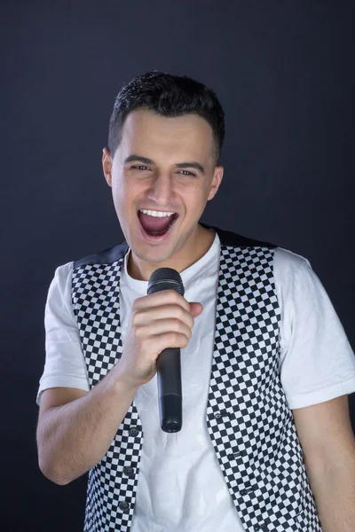 Young male black-haired rock vocalist performs singing to microp — Stock Photo, Image