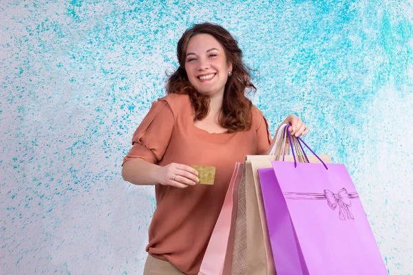 Счастливая улыбающаяся женщина, держа в руках разноцветные бумажные пакеты для покупок, b — стоковое фото