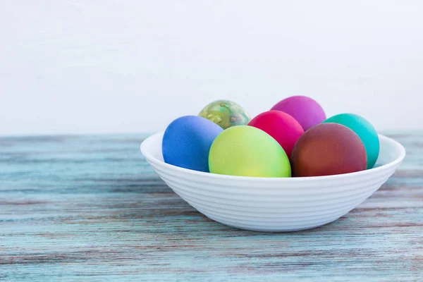 Λευκό πιάτο με το Πάσχα versicolored βραστά αυγά στο ξύλινο backg — Φωτογραφία Αρχείου