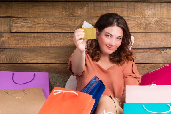Женщина за магазином на кровати с бумажными пакетами, банковская карта — стоковое фото
