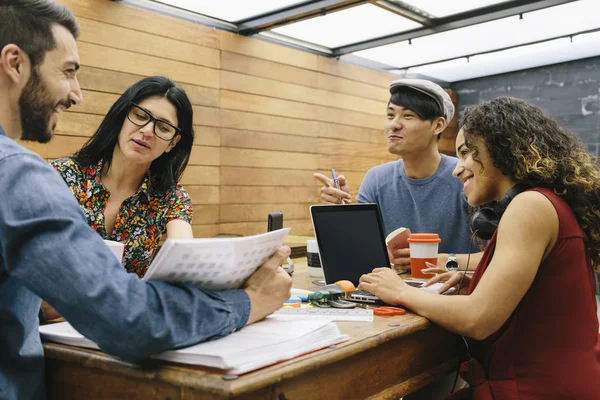 Four person multiethnic startup discussing ideas in the office