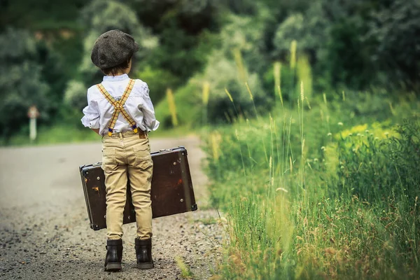 Siyah şapkalı genç bavulla Büyük Şehir 'e gidiyor.