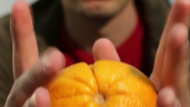 Великий апельсин в людських руках — стокове відео