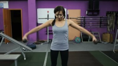 Spor salonunda dumbbells ile atletik genç kadın fırsatlar