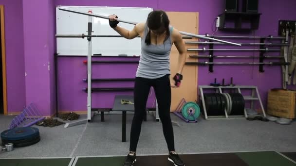 La chica se está preparando para una sesión de entrenamiento en el gimnasio — Vídeos de Stock