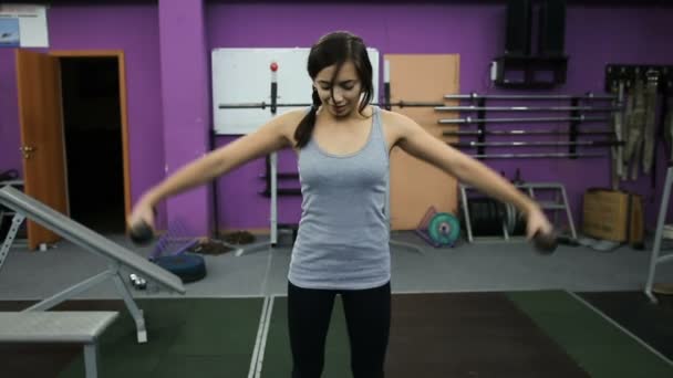 Atletica giovane donna si occupa di manubri in palestra — Video Stock